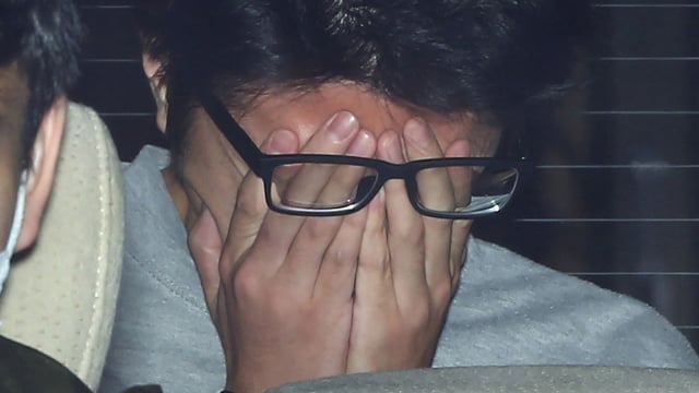 (FILES) This file photo taken on November 1, 2017 shows suspect Takahiro Shiraishi covering his face with his hands as he is transported to the prosecutor's office from a police station in Tokyo. 