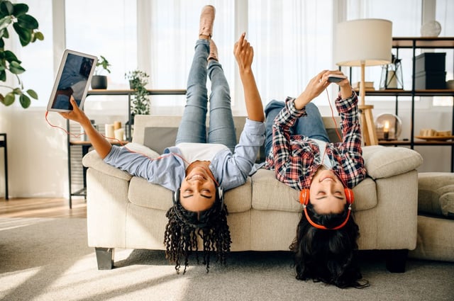 Dos chicas jóvenes escuchan música con auriculares.