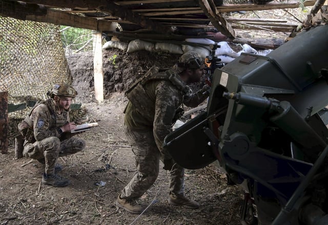 Militares ucranianos de la 101ª Brigada de la Guardia del Estado Mayor se preparan para disparar un obús D-30 de 122 mm hacia las posiciones rusas.