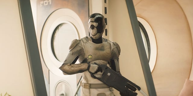 Murderbot holding a gun and wearing its helmet up in Episode 8