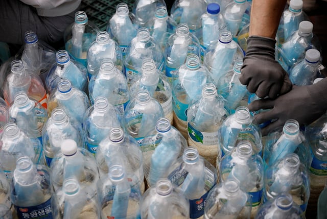 Members of North Korean defector group Kuensaem fill empty plastic bottles with rice and masks, during preparations for an event to send the bottles towards the North, in Seoul, South Korea, June 18, 2020. REUTERS/Kim Hong-Ji/File Photo