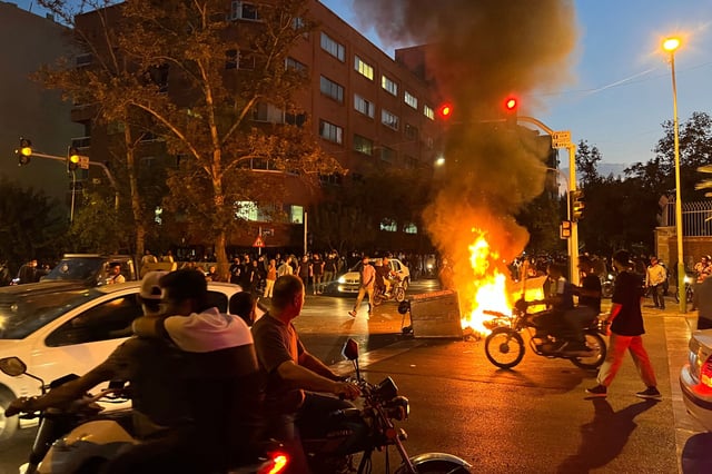 Iranians gather around a burning barricade during a protest in Tehran in 2022 for Mahsa Amini, a woman who died after being arrested by the Islamic Republic's "morality police."