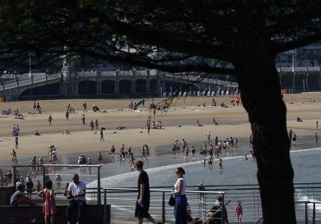 Turistas y donostiarras disfrutan de un día soleado en la playa de la Concha de San Sebastián