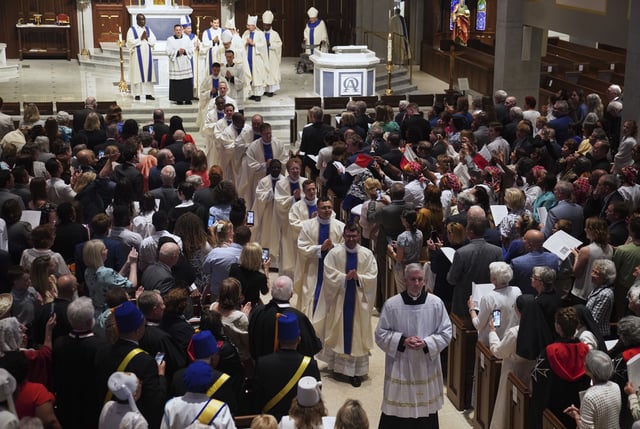 Twelve newly ordained priests walk past pews of family, friends and community members, after their ordination Mass at the Cathedral of Saint Thomas More in Arlington, Va., on Saturday, June 7, 2025. (AP Photo/Jessie Wardarski)