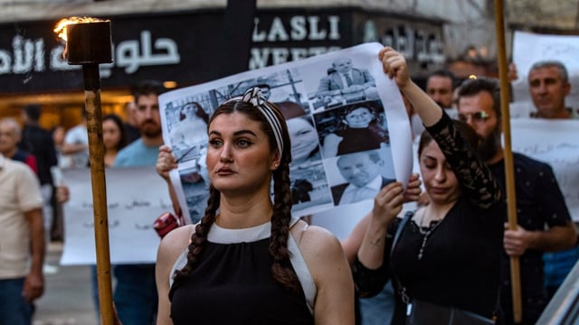 Christian Syrians march in the northeastern city of Qamishli to express their solidarity with the victims of the bombing