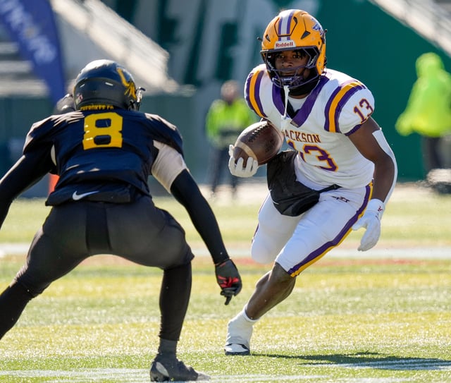 Dec 6, 2024; Birmingham, AL, USA; Jackson's Ezavier Crowell (13) tries to evade a tackle by Cherokee County's Tyson Wood (8) at Protective Stadium in the AHSAA 4A State Championship game.