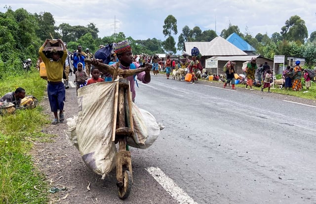 A Congolese civilian pushes a Tshukudu (a wooden bike used for transporting goods) as they flee near the Congolese border with Rwanda after fightings broke out in Kibumba, outside Goma in the North Kivu province of the Democratic Republic of Congo May 24, 2022. REUTERS/Djaffar Sabiti/File photo
