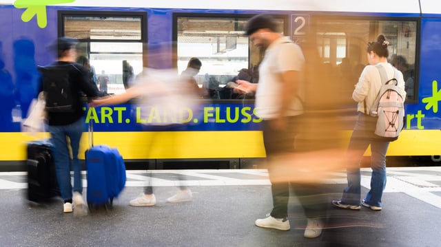 Menschen an einem Gleis in Hannover vor einem Regionalzug