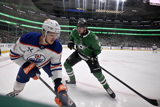May 29, 2025; Dallas, Texas, USA; Edmonton Oilers center Trent Frederic (21) skates with the puck against Dallas Stars defenseman Lian Bichsel (6) in game five of the Western Conference Final of the 2025 Stanley Cup Playoffs at American Airlines Center. Mandatory Credit: Jerome Miron-Imagn Images