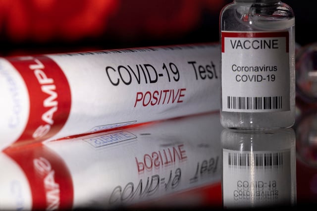 A test tube labelled "COVID-19 Test Positive" and a vial labelled "VACCINE Coronavirus COVID-19" are seen in this illustration taken December 11, 2021. REUTERS/Dado Ruvic/Illustration/File Photo