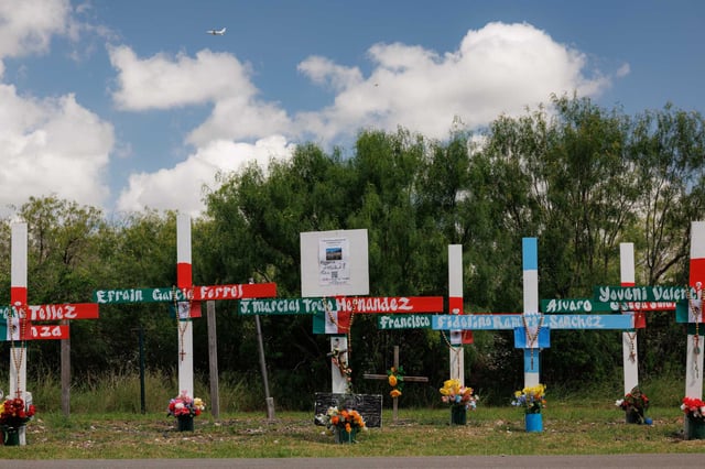 Crosses and flowers at a memorial on Quintana Road honor the 53 migrants who died after being locked in a sweltering trailer in south San Antonio in 2022.