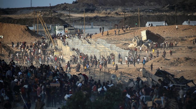 Menschen haben sich an einem Verteilzentrum der privaten GHF-Stiftung nahe Nuseirat im Gazastreifen versammelt.