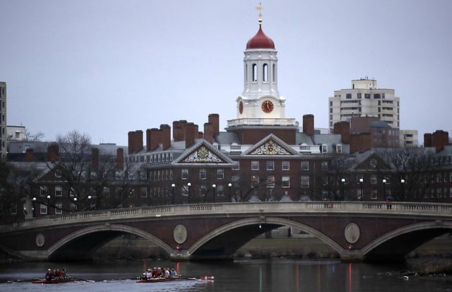 FILE - Rowers paddle down the Charles River near the campus of Harvard University in Cambridge, Mass., March 7, 2017. 