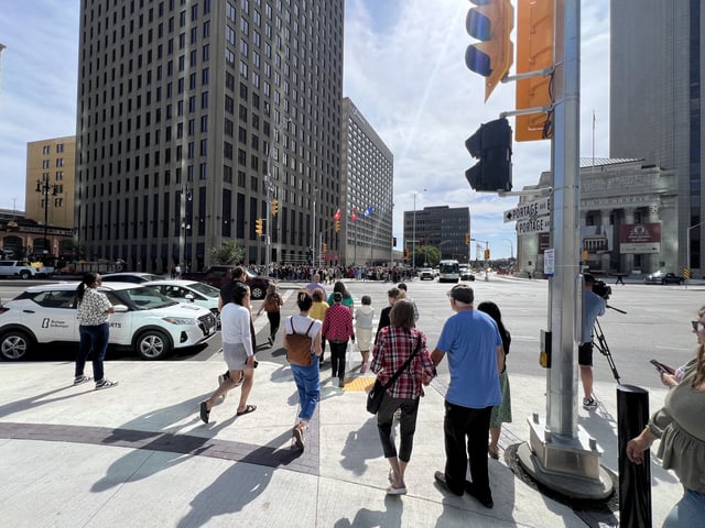 Pedestrians walk across the intersection of Portage Avenue and Main Street for the first time in decades. 