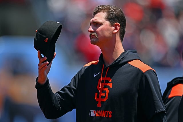 San Francisco Giants pitcher Sean Hjelle (64) removes his cap for the national anthem before the start of their MLB game at Oracle Park in San Francisco, Calif., on Sunday, June 22, 2025. (Jose Carlos Fajardo/Bay Area News Group)