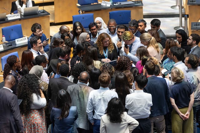 Delegates huddle during informal consultations on the GGA. Credit: IISD/ENB - Kiara Worth