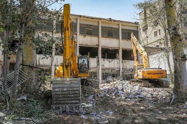 Photo obtenue auprès de l'agence de presse judiciaire iranienne Mizan Online, le 25 juin 2025, d'engins de chantier déblayant les décombres à l'extérieur du complexe pénitentiaire d'Evin à Téhéran touché par une frappe israélienne