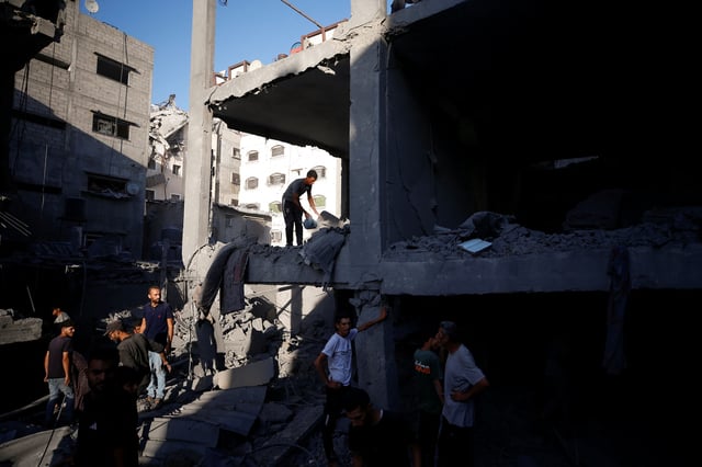 Palestinians inspect the site of an Israeli air strike on a house in Gaza City, June 27, 2025. REUTERS/Mahmoud Issa