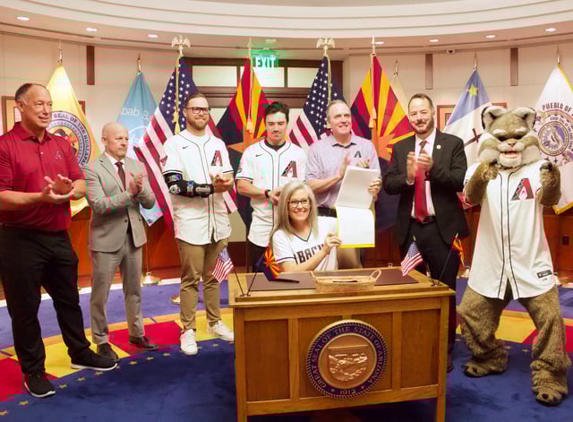 Arizona Gov. Katie Hobbs signed a bill June 27, 2025, to fund improvements at Chase Field, home of the Arizona Diamondbacks. Also pictured are the Dbacks' Luis Gonzalez, Hobbs' Chief of Staff Chad Campbell; pitcher Corbin Burnes; right fielder Corbin Carroll; President, CEO and general partner Derrick Hall; Rep. Jeff Weninger, R-Chandler, and team mascot Baxter.