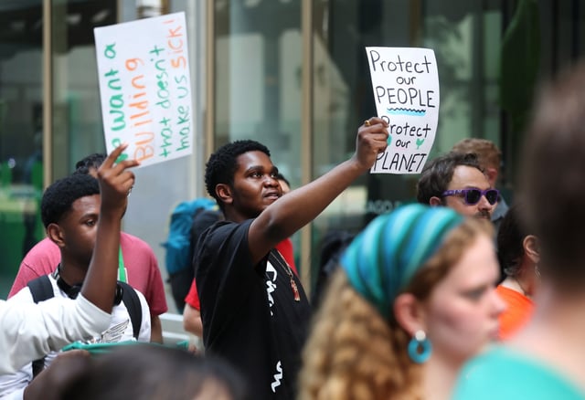 Zion Richards, a Curie High School senior, holds a sign reading “Protect our People, Protect our Planet” while attending a Chicago Teachers Union press conference outside of Chicago Public Schools headquarters prior to a CPS monthly board meeting on June 26, 2025.  (Chris Sweda/Chicago Tribune)