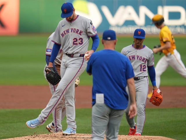 New York Mets pitcher David Peterson (23) waits for a visit from pitching coach Jeremy Hefner, center right, during the second inning of a baseball game against the Pittsburgh Pirates in Pittsburgh, Friday, June 27, 2025. (AP Photo/Gene J. Puskar)