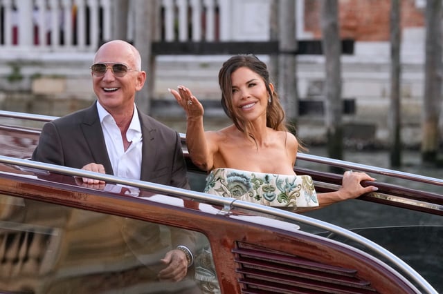 Jeff Bezos, left, and Lauren Sanchez leave a hotel for their pre-wedding reception, in Venice, Italy, Thursday, June 26, 2025. (AP Photo/Luca Bruno)
