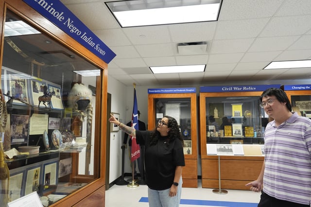 Director of Education Dr. Michelle Tovar, center, and archivist Jason Fung describe how current displays will be redone inside the Buffalo Soldiers National Museum on Friday, June 27, 2025, in Houston, Texas. (AP Photo/Ashley Landis)