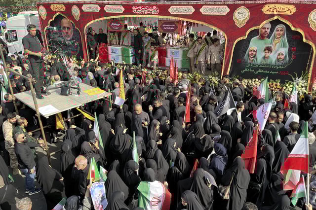 People mourn over the flag-draped coffins of Iranian army generals, nuclear scientists and their family members who were killed in Israeli strikes, during a funeral ceremony in Tehran, Iran, Saturday, June 28, 2025. (AP Photo/Vahid Salemi)