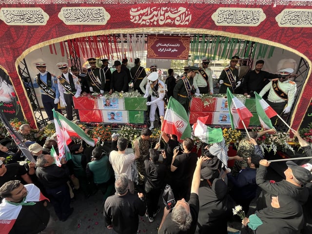 People mourn over the flag-draped coffins of Iranian nuclear scientists who were killed in Israeli strikes, during a funeral ceremony in Tehran. Iran, Saturday, June 28, 2025. (AP Photo/Vahid Salemi)