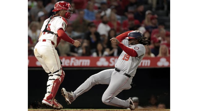 The Washington Nationals’ Josh Bell slides safely home to score the go-ahead run in front of Angels catcher Logan O’Hoppe during the seventh inning on Friday night at Angel Stadium. The Nationals scored in seven of the nine innings to rally past the Angels, 15-9. (Photo by Ronald Martinez/Getty Images)