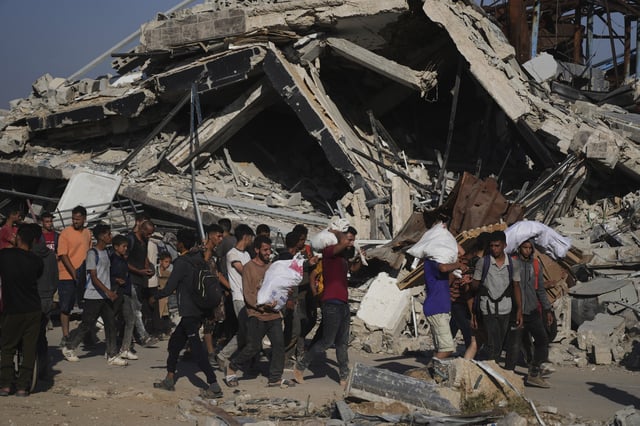 Palestinians carry humanitarian aid packages distributed by the Gaza Humanitarian Foundation operated by the U.S.-backed organization in Khan Younis, southern Gaza Strip, Thursday, June 26, 2025. (AP Photo/Abdel Kareem Hana)