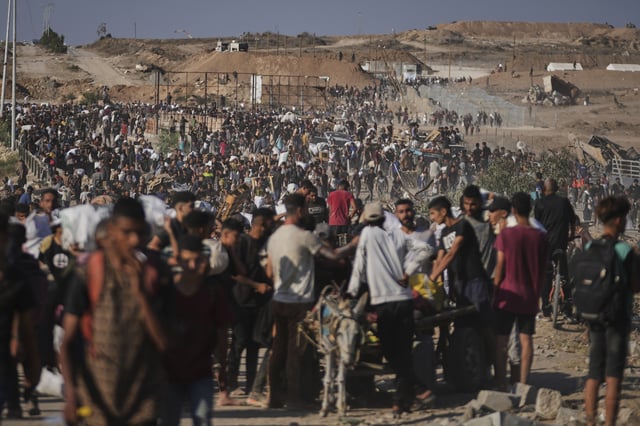 Palestinians carry humanitarian aid packages near the Gaza Humanitarian Foundation distribution center operated by the U.S.-backed organization in Khan Younis, southern Gaza Strip, Thursday, June 26, 2025. (AP Photo/Abdel Kareem Hana)