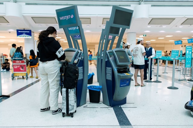 Travelers at a Westjet check-in counter in Toronto Pearson International Airport on June 30, 2024.