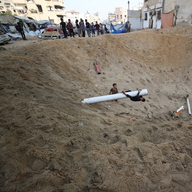 Palestinians gather at the site of a tent camp that was struck by an Israeli airstrike on Friday in Gaza City.