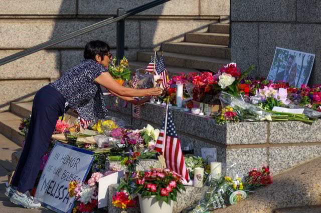 A woman lays flowers at a makeshift memorial for DFL State Rep. Melissa Hortman and her husband Mark Hortman at the Minnesota State Capitol building on June 16, 2025, in St. Paul, Minn.