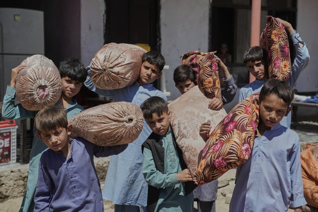 Afghan children from families repatriated from Pakistan carry pillows as they are relocated to their new residence in Kabul, Afghanistan, Tuesday, June 3, 2025. (AP Photo/Ebrahim Noroozi)