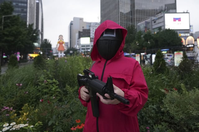 Un fan con máscara y disfraces inspirados en la serie coreana original de Netflix "El Juego del Calamar" posa para una foto en Seúl, Corea del Sur, el sábado 28 de junio de 2025. (Foto AP/Lee Jin-man)