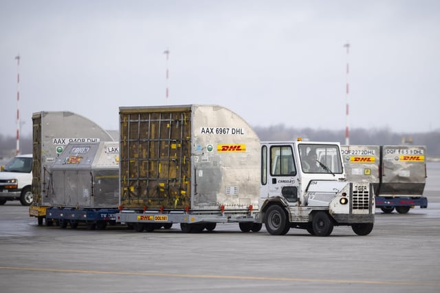 DHL containers are transported on the tarmac at John C. Munro Hamilton International Airport in Hamilton, Ont., Wednesday, March 26, 2025.  THE CANADIAN PRESS/Nick Iwanyshyn