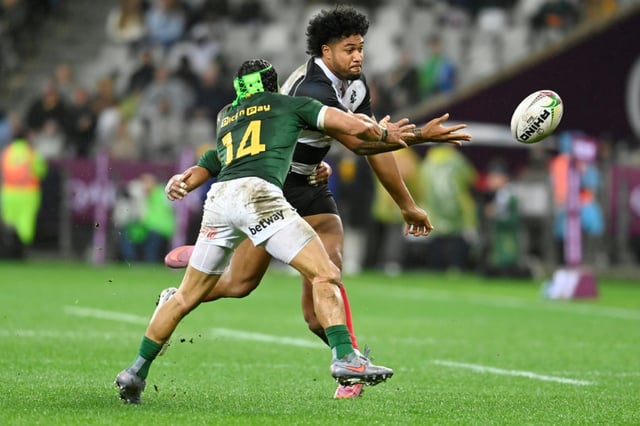 South Africa winger Cheslin Kolbe (L) tackles Barbarians centre Leicester Fainga'anuku at Cape Town Stadium