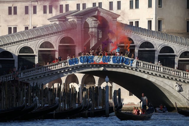 Demonstrators on the Rialto Bridge stand by a banner that reads 'No space for Bezos' in Venice on Saturday.