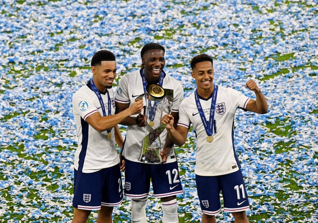 Soccer Football - UEFA Under 21 Championship - Final - England v Germany - Tehelne pole, Bratislava, Slovakia - June 28, 2025 England's Ethan Nwaneri, Brooke Norton-Cuffy and Omari Hutchinson celebrate with the trophy after winning the final REUTERS/Radovan Stoklasa     TPX IMAGES OF THE DAY