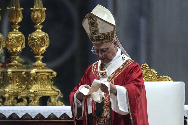 Pope Leo XIV look at a pallium, he blessed for the new metropolitan archbishops during a Mass in St. Peter's Basilica at the Vatican, Sunday, June 29, 2025. (AP Photo/Andrew Medichini)