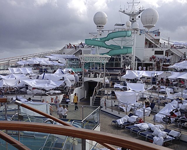 This Feb. 10, 2013, photo provided by Kalin Hill, of Houston, shows passengers with makeshift tents on the the deck of the Carnival Triumph cruise ship at sea in the Gulf of Mexico. About three dozen passengers aboard the ill-fated cruise liner have filed a lawsuit in Miami hoping to collect thousands of dollars as a result of lingering medical and mental issues they claim were caused by their nightmarish experience. (AP Photo/Kalin Hill, File)