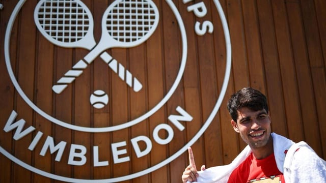 Spain's Carlos Alcaraz shows a Wimbledon sign as he leaves court after warming up during the 2025 Wimbledon Championships at The All England Lawn Tennis and Croquet Club in Wimbledon, southwest London, on June 29, 2025. (Photo by HENRY NICHOLLS / AFP) / RESTRICTED TO EDITORIAL USE (AFP)