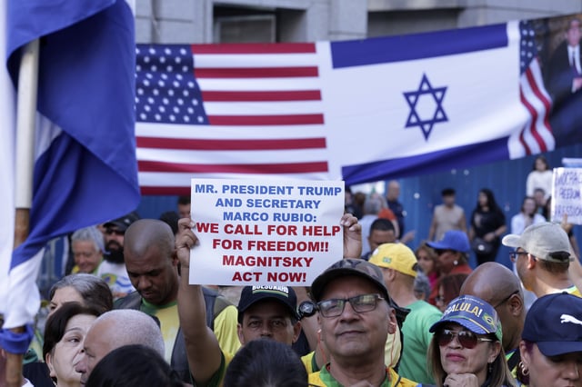 Supporters of former President Jair Bolsonaro protest his Supreme Court trial, in which he is accused of involvement in a 2022 coup attempt, in front of an American and an Israeli flag, in Sao Paulo, Sunday, June, 29, 2025. (AP Photo/Ettore Chiereguini)