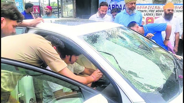 Police officials inspecting the Audi car after the incident in Jamalpur, Ludhiana, on Sunday. (HT Photo)