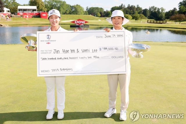 Im Jin-hee (L) and Lee So-mi of South Korea hoist their trophies and ceremonial check after winning the Dow Championship at Midland Country Club in Midland, Michigan, on June 29, 2025, in this Getty Images photo. (Yonhap)