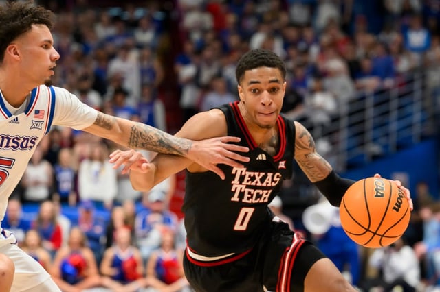 Texas Tech guard Chance McMillian (0) drives against Kansas guard Zeke Mayo, left, during the second half of an NCAA college basketball game in Lawrence, Kan., Saturday, March 1, 2025. (AP Photo/Reed Hoffmann)