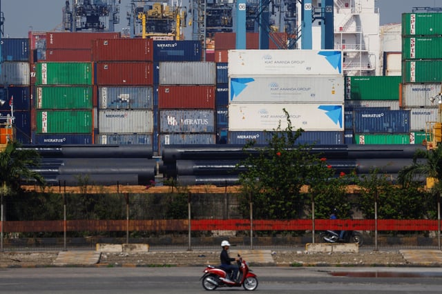A motorcycle rider drives past stacks of containers at the Tanjung Priok port in Jakarta, Indonesia, April 3, 2025. REUTERS/Ajeng Dinar Ulfiana/File Photo
