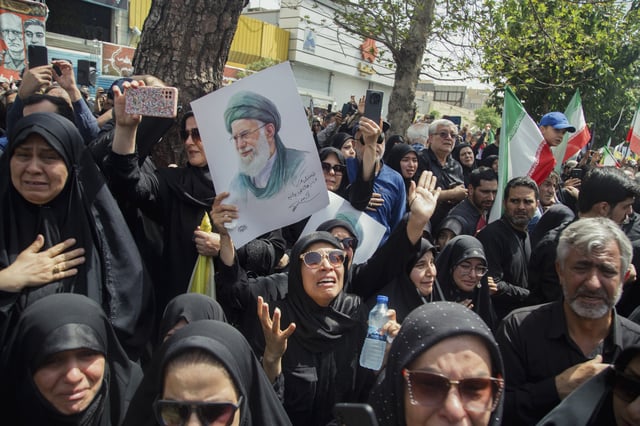 A woman mourns as she holds a poster showing the images of Iran&#39;s Supreme Leader Ali Khamenei at Tehran&#39;s Azadi (Freedom) Street on June 28, 2025, in the state funeral procession of Iranian military commanders and scientists killed in Israeli strikes.